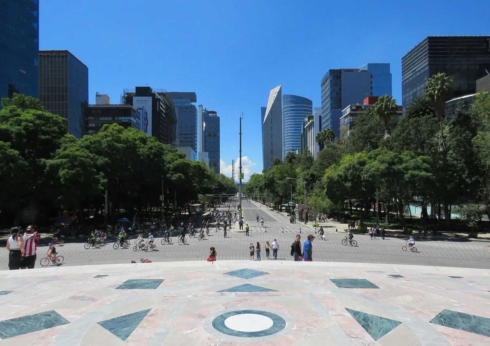 Vista diurna del Paseo de la Reforma en Ciudad de México, con tráfico, árboles y edificios altos.