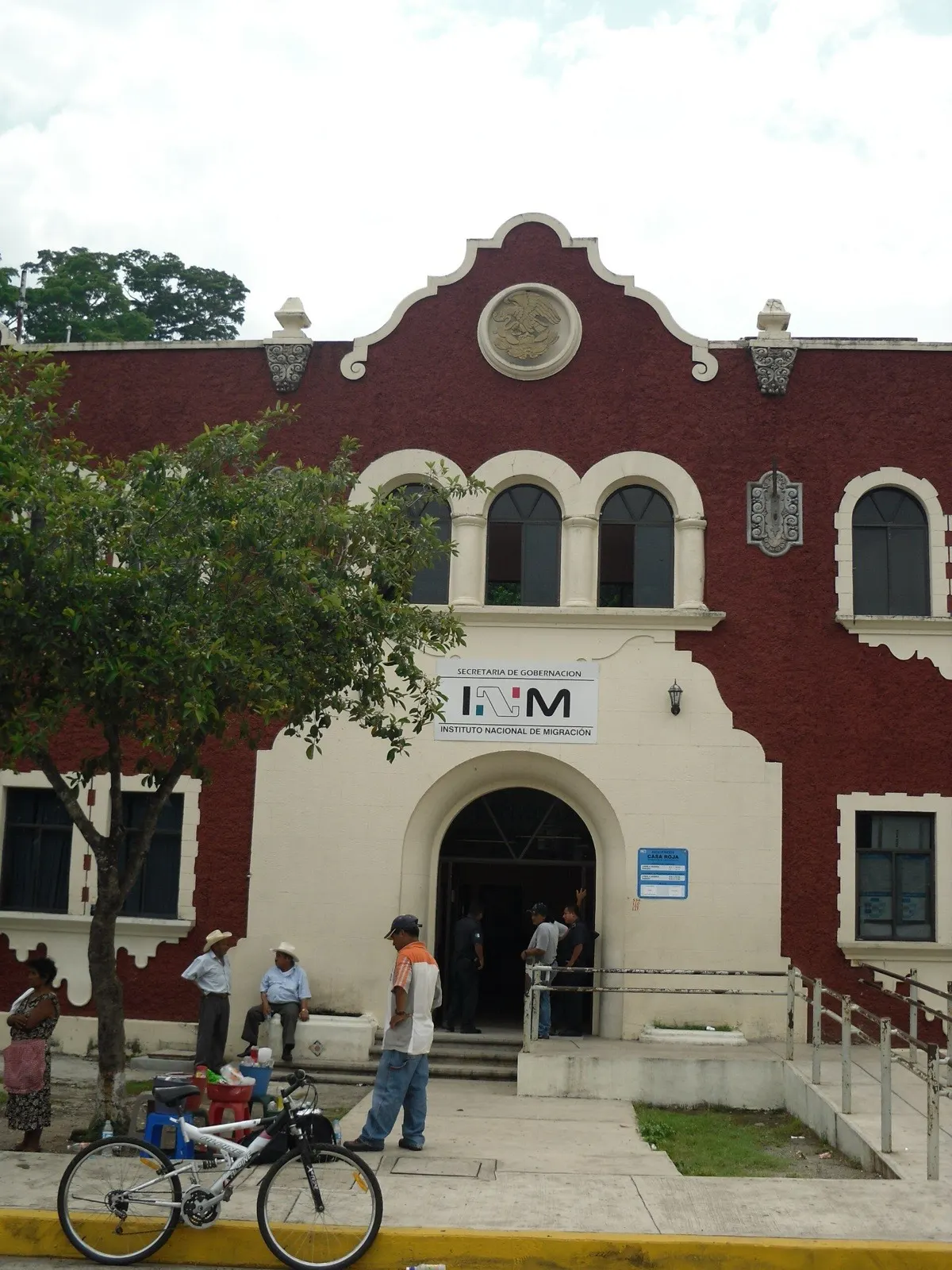 Entrada de una oficina del Instituto Nacional de Migración en México, con el letrero del INM sobre la puerta.