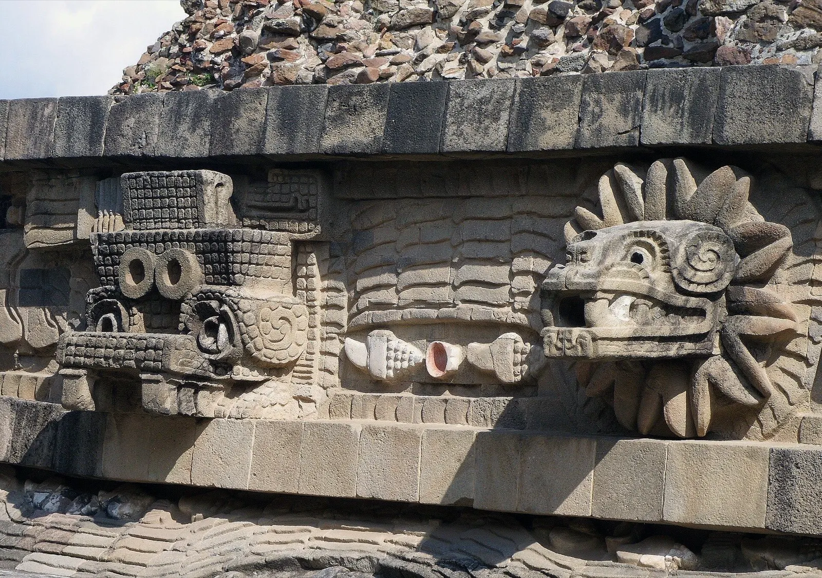 Detalle escultórico del Templo de la Serpiente Emplumada en Teotihuacán que muestra el trabajo de piedra y pigmento original.